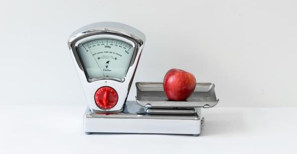 Vintage kitchen scale with a red apple, encouraging newsletter subscription.